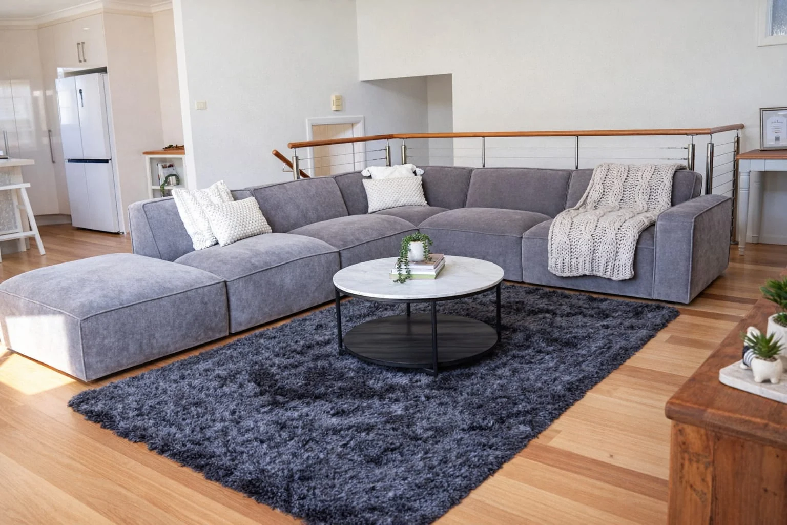 Living room at The Gables Berry with grey sectional sofa and round coffee table