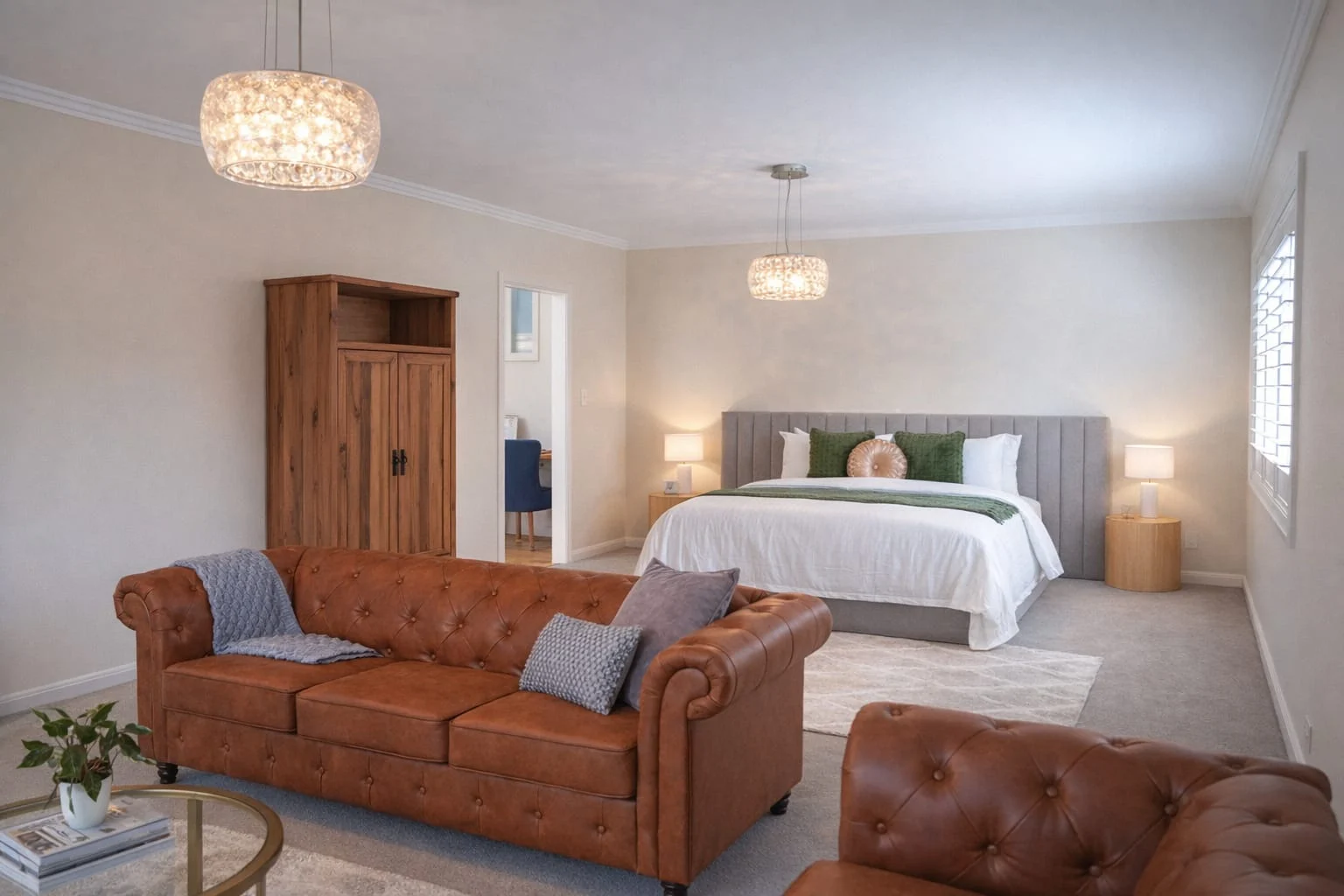 Bedroom and private lounge area with upholstered bed and leather sofas at The Gables Berry
