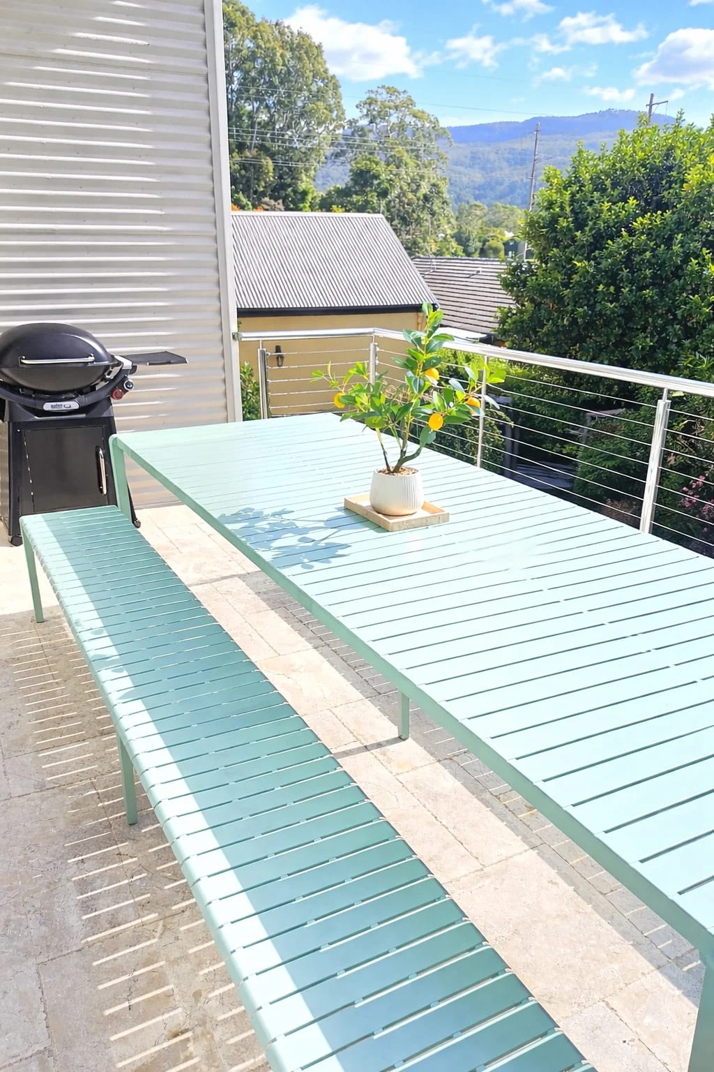 The Gables Berry deck with pale green outdoor table and benches overlooking trees and distant hills